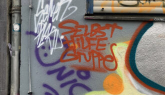 Ein Graffiti auf dem "Selbsthilfegruppe" steht